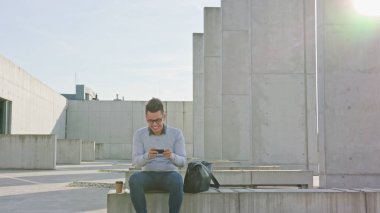 Genç bir adam dışındaki bir telefon kullanma