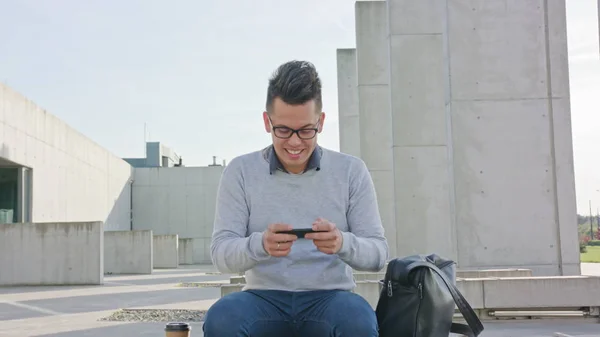 Молодой человек, использующий телефон снаружи — стоковое фото