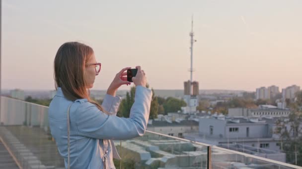 Egy fiatal hölgy fényképezni a városban. — Stock videók