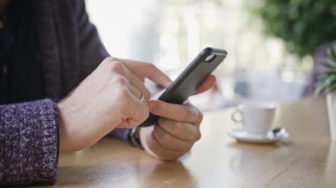 Bir akıllı telefon Cafe kullanan bir genç adam