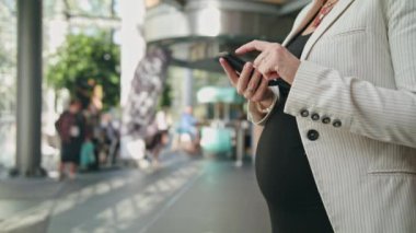 Genç hamile bir kadının bir Smartphone kullanarak