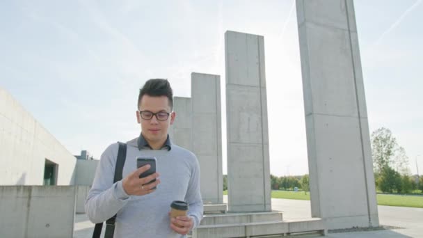 Um jovem usando um telefone fora — Vídeo de Stock