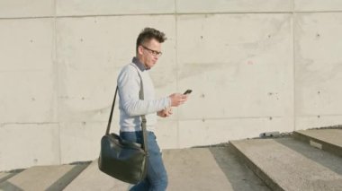 Genç bir adam dışındaki bir telefon kullanma