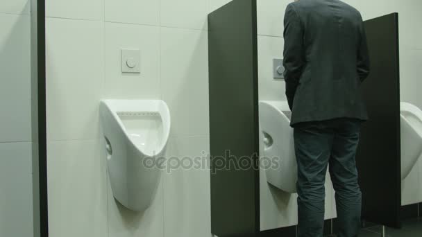 Man plassen te urinoir in het toilet — Stockvideo