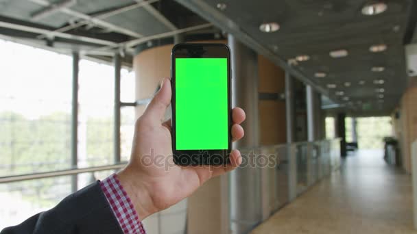 Uma mão segurando um telefone com uma tela verde — Vídeo de Stock