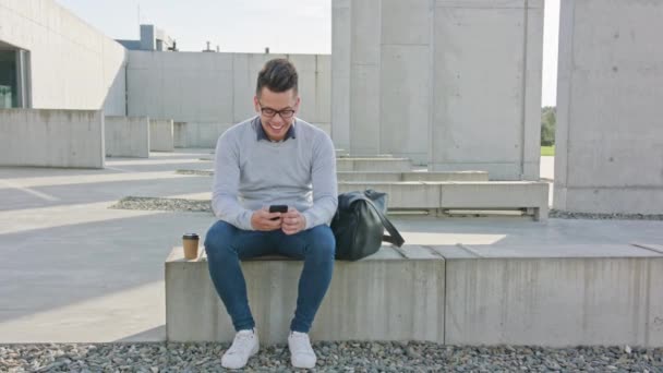 Młody człowiek, korzystając z telefonu poza — Wideo stockowe