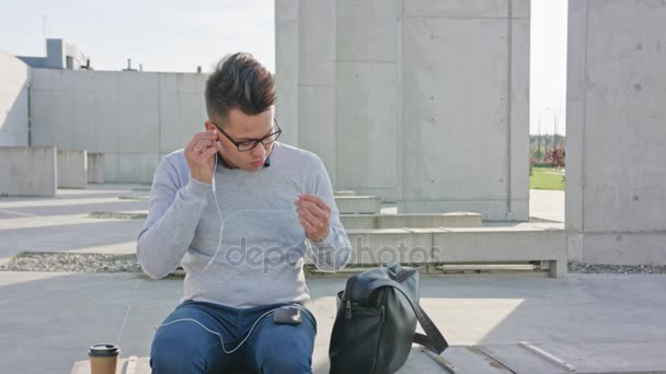 Um jovem usando um telefone fora — Vídeo de Stock