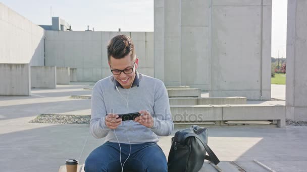 Een jonge Man met behulp van een telefoon buiten — Stockvideo