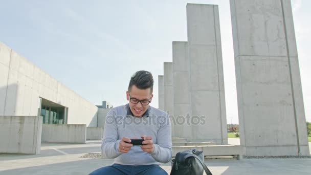 Een jonge Man met behulp van een telefoon buiten — Stockvideo