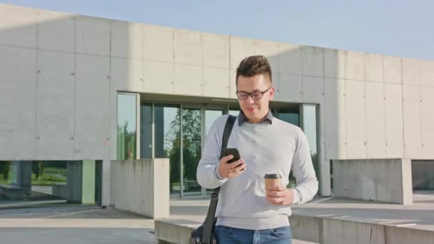 Een jonge Man met behulp van een telefoon buiten — Stockvideo