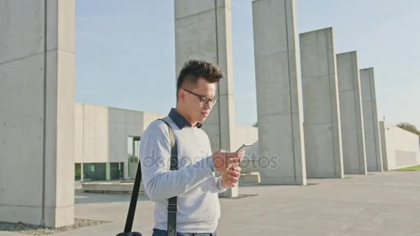 Ein junger Mann, der draußen telefoniert — Stockvideo