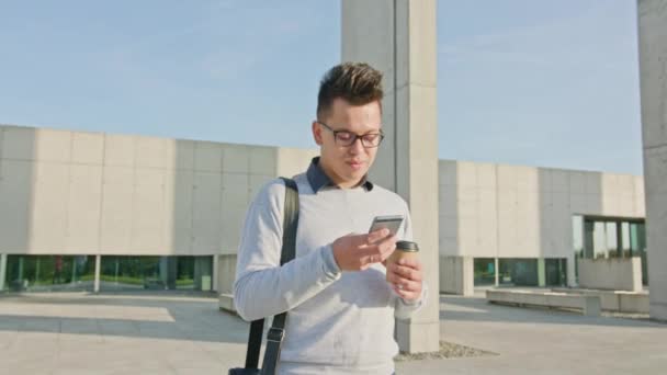 Ein junger Mann, der draußen telefoniert — Stockvideo