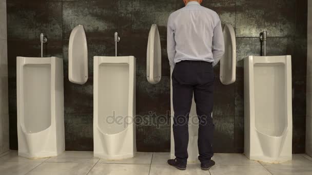 Man plassen te urinoir in het toilet — Stockvideo