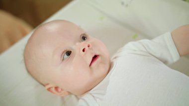 Evde yatakta yatan bebek. Ağzı açık