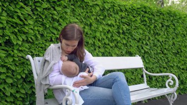 Bir kadın emzirme çocuğunu Park