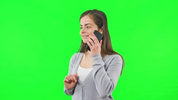Жінка ізольована на зеленому екрані з телефоном — стокове фото