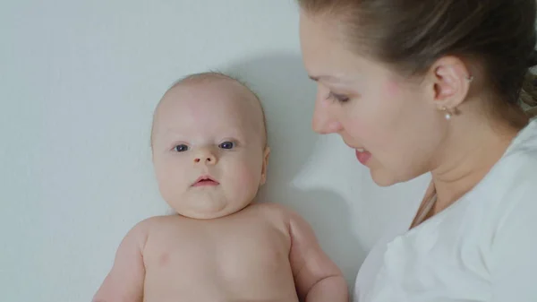 Mère avec bébé au lit câlins . — Photo