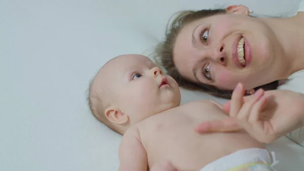 Mère avec bébé au lit câlins . — Photo