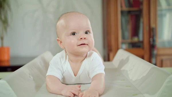 その腹を自宅のベッドで赤ちゃん横たわる。口を開けて — ストック写真