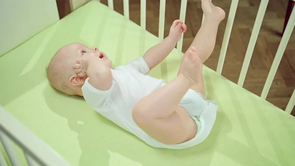 Baby Lying in a Crib at Home and Playing — Stock Photo, Image