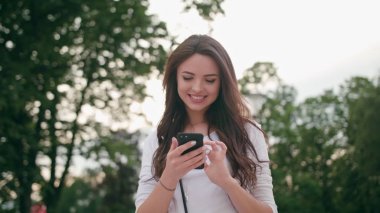 Cep telefonu açık havada kullanarak güzel bir esmer