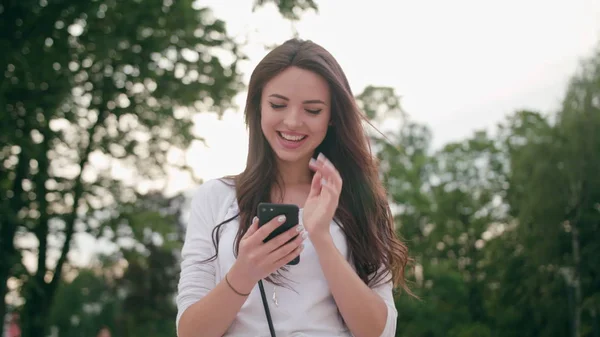 Красивая брюнетка с помощью мобильного телефона на открытом воздухе — стоковое фото