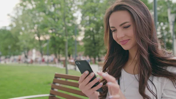 A Beautiful Brunette Using a Mobile Phone Outdoors — Stock Photo, Image