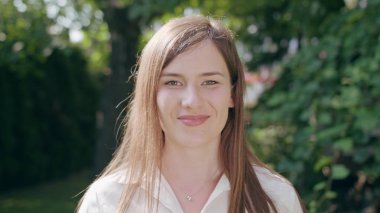 Genç Bayan kameraya bakarak ve gülümseyen