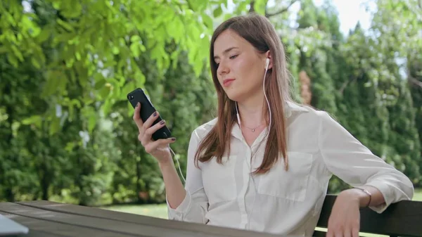 Lady i parken Lyssna på musik på telefonen — Stockfoto