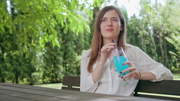 Kadın parkta güler yüzlü içme