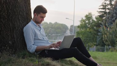 genç bir adam bir dizüstü bilgisayar açık havada kullanma