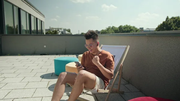 Un giovane che usa uno smartphone sulla terrazza . — Foto Stock