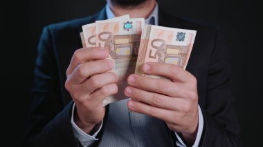 Bir adam siyah ceket ve beyaz gömlek nakit Holding