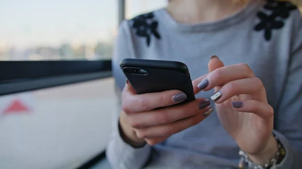 En ung dam som använder en smartphone på bussen — Stockfoto