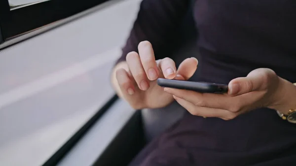 En ung dam som använder en smartphone på bussen — Stockfoto