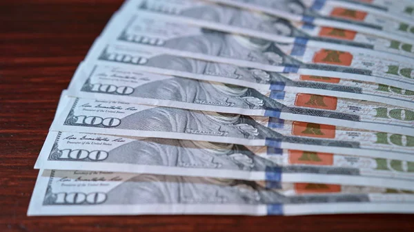 Заборонена купа стодоларових банкнот на столі — стокове фото
