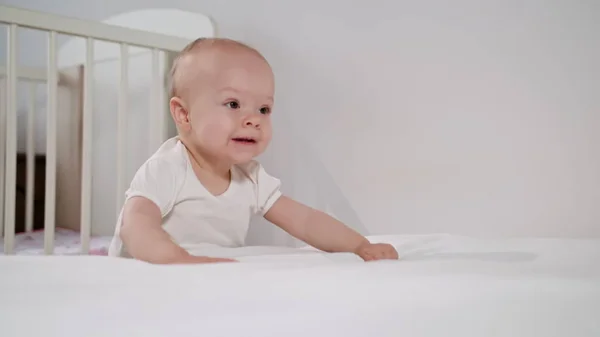 Baby står nära sängen hemma — Stockfoto
