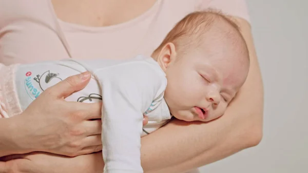 Baby i mödrar armar somna — Stockfoto