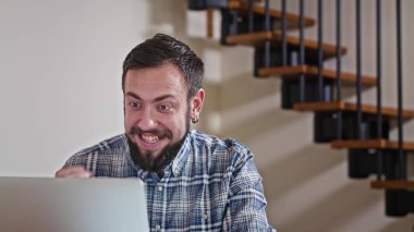 Evde dizüstü bilgisayarla çalışan bir adam