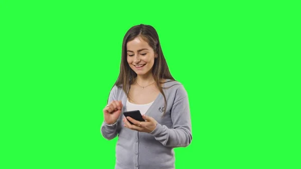 Жінка ізольована на зеленому екрані з телефоном — стокове фото
