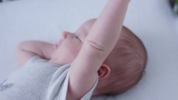 Bebé acostado en la cama en casa — Vídeo de stock