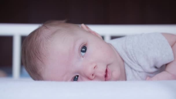 Младенец, лежащий в кровати дома — стоковое видео