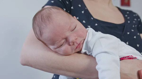 Ung mamma hålla sitt barn i famnen — Stockfoto