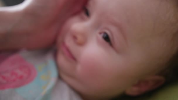 Mano femenina tocando a un bebé acostado en la cama — Vídeos de Stock