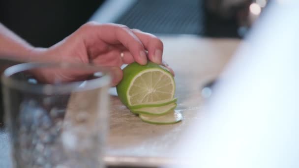Nahaufnahme von Händen, die eine Limette in der Küche aufschneiden — Stockvideo
