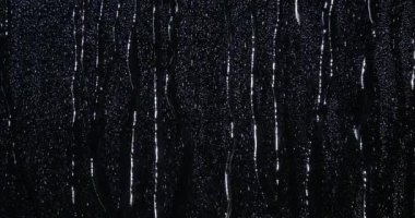 Siyah camların üzerinde akan su damlacıkları.