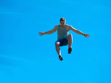 Zıplayan adam kadar. Arka plan mavi gökyüzü.