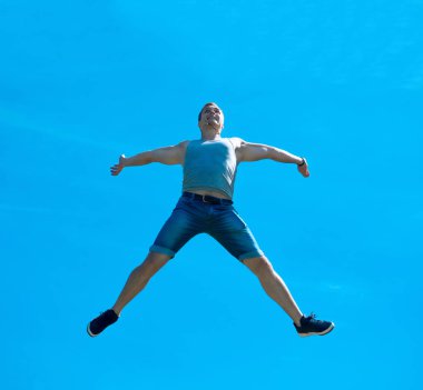 Zıplayan adam kadar. Arka plan mavi gökyüzü.