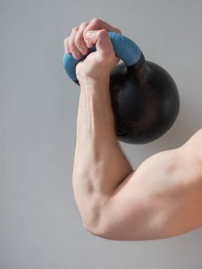 Gri arka plan üzerinde izole dumbbell tutarak elini. Yakın, sağlıklı yaşam kavramı.