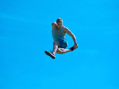 Zıplayan adam kadar. Arka plan mavi gökyüzü.